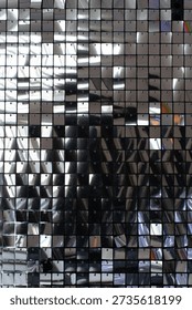 Shining silver sequin wall background with shimmering metallic square scales