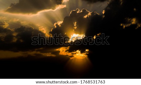 shining sun under dark cloud