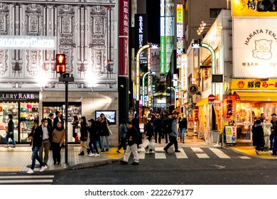 Shinjuku, Japan - April 3, 2019: People Walking On Famous Shopping Red Light District Kabukicho Alley Street In Downtown City With Many Neon Bright Lights At Night By Stores Shops