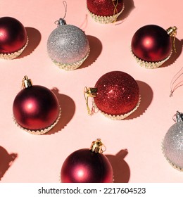 Shinny Christmas Baubles In Cupcake Liners, Creative Winter Holidays Pattern On Pastel Pink Background. 