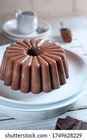 Shinny Glimmerings Chocolate Pudding  With Gritty Lines Motif On White Plate Over Wooden White Table