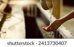 Shinto temple, closeup and washing hands with water in container for cleaning, faith and wellness. Religion, mindfulness and purification ritual to stop evil, bacteria and peace at shrine in Tokyo