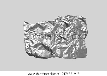 Shiny aluminum foil wrap without chocolate candy on a gray background. Texture of used crumpled aluminium food foil.