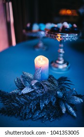 Shiny Blue Candle And Sparkling Blue Feather Made As A Centerpiece Of Dinner Table