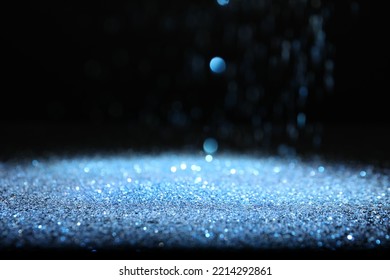 Shiny Blue Glitter Falling Down On Black Background. Bokeh Effect