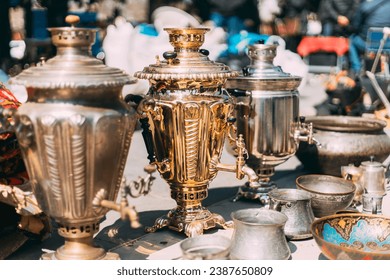Shiny Bright Samovars Stand In A Row. Tea Party Concept And Hospitality. Traditional Russian Samovar At Flea Market. Vintage Copper Samovar. Since Ancient Times In Russia, All Guests Were Offered To