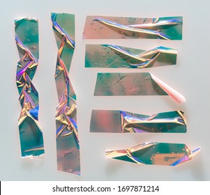 Shiny zerbrochene Aufkleber mit echtem Schatten. Schöner Satz von metallischen, holografischen Klebebandformen einzeln auf weißem Plastikhintergrund. Holo glänzende Streifen oder Snips für Ihr Design-Poster.