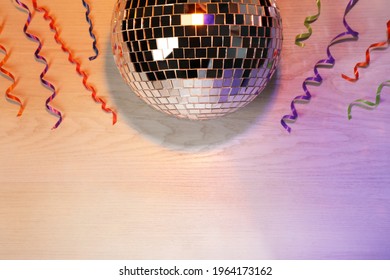 Shiny disco ball and serpentine streamers on white wooden background, flat lay. Space for text - Powered by Shutterstock