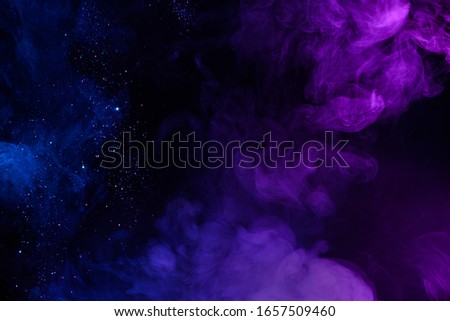 Shiny glitter in clouds of pink and blue fog smoke abstract background