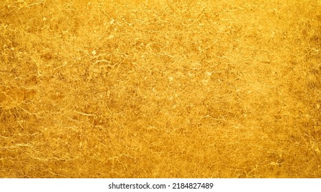 Shiny gold background made of rough textured gold paper. - Shutterstock ID 2184827489