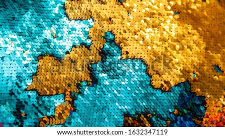 Shiny gold blue sequins background texture backdrop. Light stylish shining spangles pattern. Sequinned material, cloth, pillow fabric closeup macro Earth land and water sea map abstract visual concept
