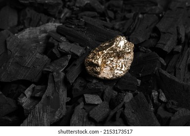 Shiny gold nugget on coals, closeup view
