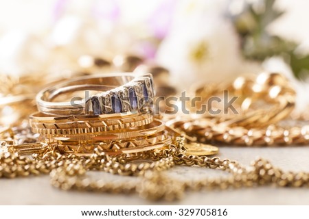 shiny gold and silver jewelery on white table