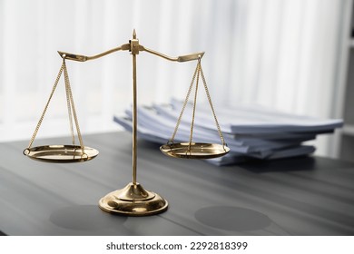 Shiny golden balanced scale and pile of legal paper on desk in lawyer office as concept justice and legal symbol. Scale balance for righteous and equality judgment by lawyer and attorney. equility - Shutterstock ID 2292818399