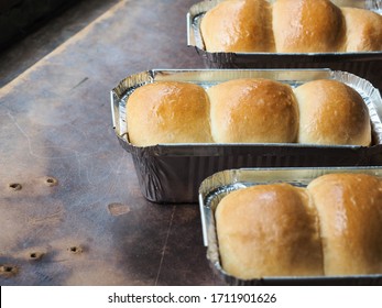 Shiny Golden Bread Rolls In Aluminium Tin Foil Box On Brown Board.