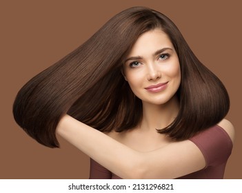 Shiny Hair Beauty Woman. Brunette Model Showing Glossy Silky Straight Hairstyle. Fashion Girl Portrait with Natural Make up and Hairdo over Beige Background