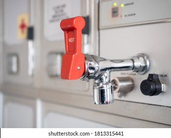 Shiny Hot Water Tap With Red Lever In Aircraft Galley.