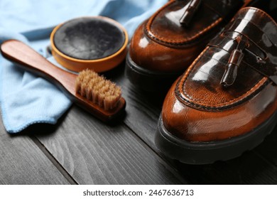 Shiny leather shoes, cloth, brush and shoe polish on black wooden background - Powered by Shutterstock