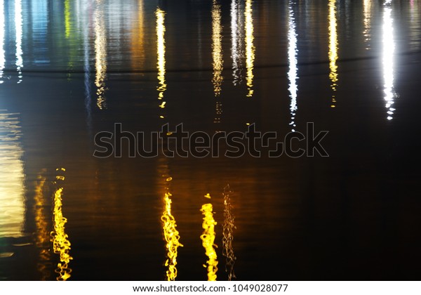 Shiny light reflections on the sea water at\
night. Abstract photo art\
backgrounds.