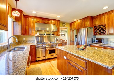 Shiny Luxury Kitchen Room With Island, Granite Tops, Steel Refrigerator, Dishwasher, Stove And Hood