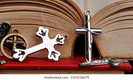 Shiny metal cross on old book to  recall the kindness of Jesus Christ for all of Christian                                - Shutterstock ID 2314136679