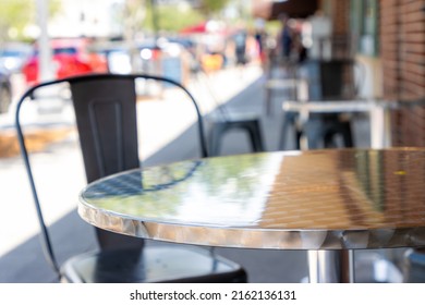 SHiny Metal Outdoor Table And Chair On Downtown Sidewalk. Selective Focus.