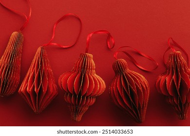 Shiny Red Paper Christmas Ornaments, winter seasonal holiday decorations on red background, copyspace, Happy  New Year holiday minimal backdrop, vivid dark color. Above view handmade Christmas bauble - Powered by Shutterstock