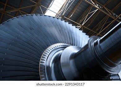 Shiny rotor of powerful steam turbine in light workshop