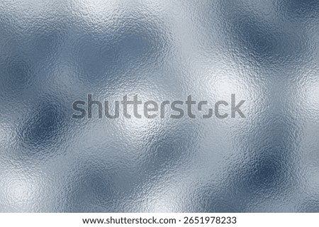 Shiny silver foil texture. Soft blue foil glass texture background. Abstract gradient bright light reflection and shiny rough texture surface. Glass effect background