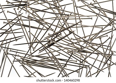 Shiny silver sewing pins on white studio background.