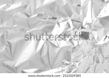 Shiny silver tinfoil surface as background, top view