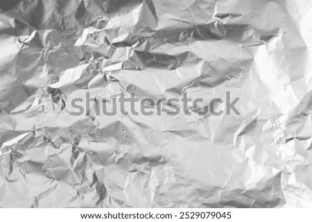 Shiny silver tinfoil surface as background, top view