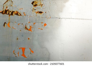 The Shiny Silver-painted Steel Sheet Peels Off And Decays Until The Inside Is Visible Orange.  It's A Scratch That Has Been Painted Over To Fix It.