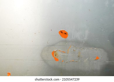 The Shiny Silver-painted Steel Sheet Peels Off And Decays Until The Inside Is Visible Orange.  It's A Scratch That Has Been Painted Over To Fix It.