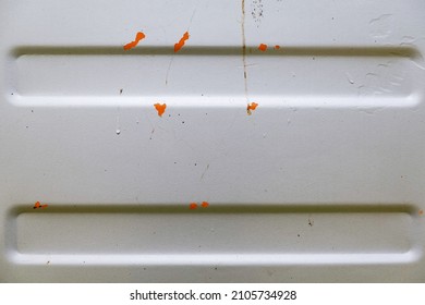 The Shiny Silver-painted Steel Sheet Peels Off And Decays Until The Inside Is Visible Orange.  It's A Scratch That Has Been Painted Over To Fix It.