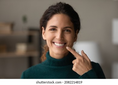Shiny smile. Portrait of young happy hispanic woman satisfied patient of dental clinic. Millennial lady enjoy perfect result of orthodontic care procedures look at camera point on white straight teeth - Shutterstock ID 2082214819