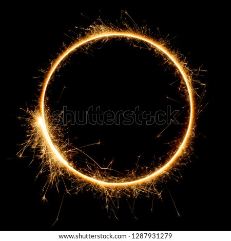 Shiny sparkler circle shape. Burning bengal fire round letter o number zero, long exposure. Burning sparklers isolated on black.