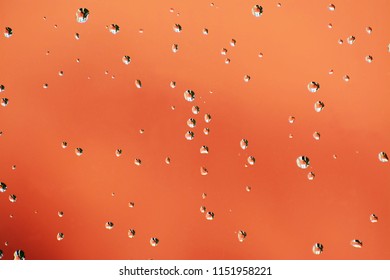 Shiny water drops on orange red background