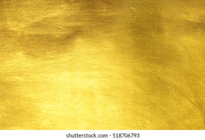 Блестящий желтый лист золотой фольги текстуры фон