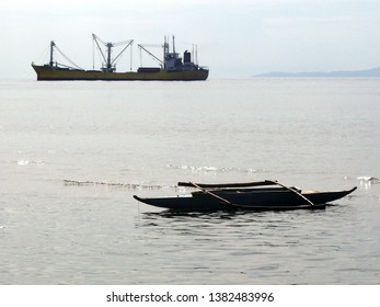 Ship At Anchor In Manila Bay With Canoe Anchored Near Shore