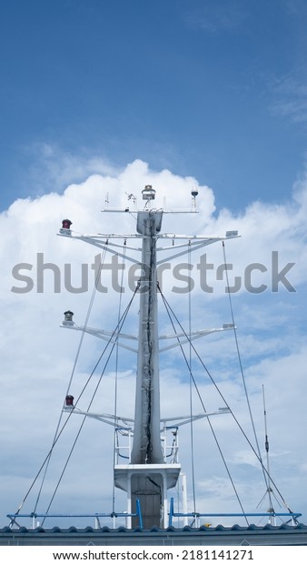 Ship\
antenna and navigation system on a ferry with sunlight and blue sky\
in the background, visible blue cloudy background. Roof radar,\
radio beacon, antennas, upper deck, cruise\
ship