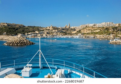 
The ship arrives at the port Mġarr the island Gozo  Malta  Beautiful city the cliffs   hills the background sunny spring day  