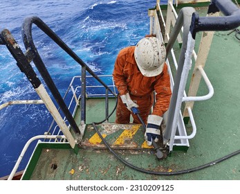 A ship crew is doing chipping to remove rust onboard a cargo ship during maintenance period