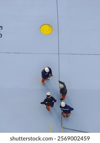 Ship crew or men are pulling a rope.