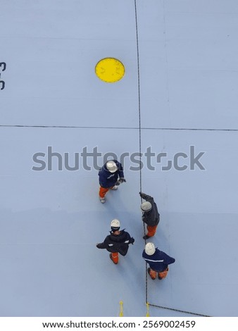 Ship crew or men are pulling a rope.
