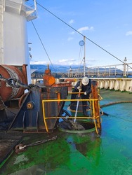 A Ship Crew Is Using Fire Hose To Remove Mud From Anchor Chain During Having Up Anchor.