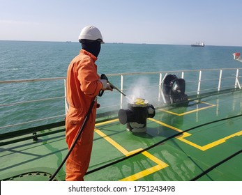 A Ship Crew Is Using High Pressure Washer To Wash On Ship Main Deck. Hydro Blast.