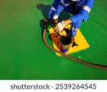 a ship crew is working or chipping during maintenance period on a cargo ship