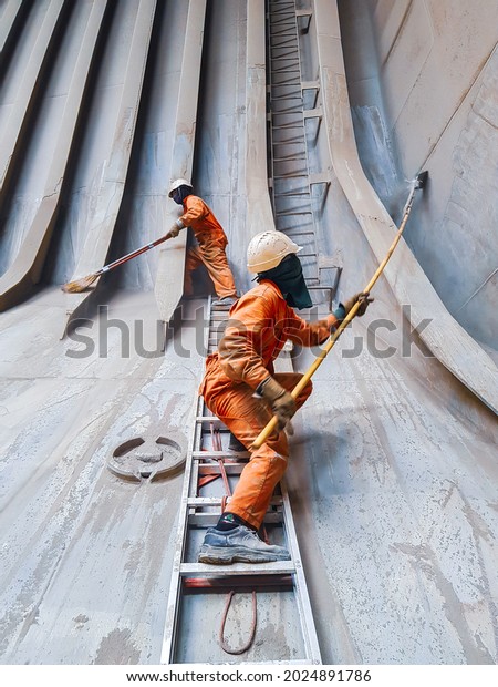ship crews are\
cleaning cargo hold and removing cargo residue on a bulk carrier\
before loading next cottage\
cargo