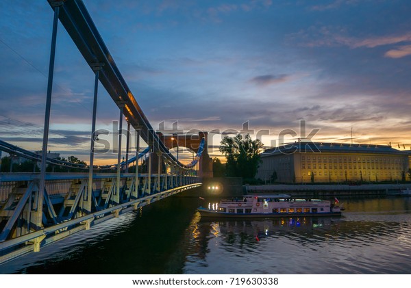 Ship excursion under beautiful bridge\
during sunset, Grunwaldzki bridge, Wroclaw,\
Poland